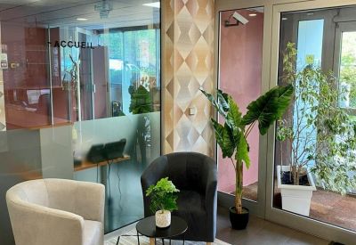 Modern reception area with velvet armchairs and geometric wallpaper.