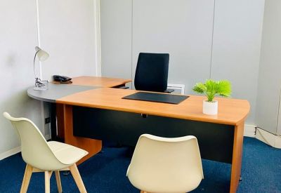 Private office with L-shaped wood desk and visitor chairs.