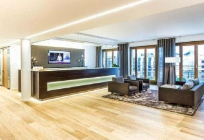 Modern reception area with a long dark wood desk and integrated linear lighting.