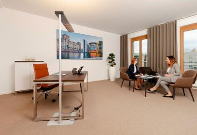 Private office suite with a wooden desk and a separate seating area for guests.