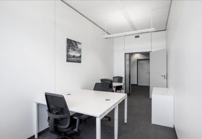 Minimalist private office with white desks and black mesh chairs.