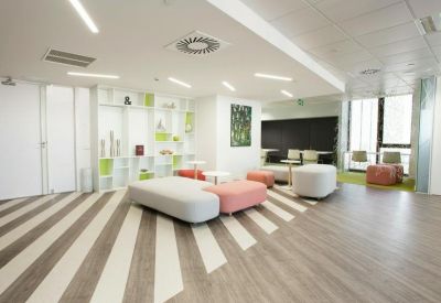 Bright communal lounge with white and pink modular seating.