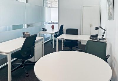 Internal four-person office suite with white desks and black ergonomic chairs.