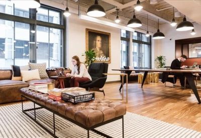 Bright coworking area featuring mid-century modern furniture and warm overhead pendant lighting.