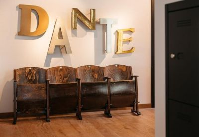 Hallway with vintage theater seating and large gold letters spelling Dante on the wall.
