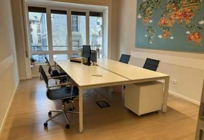 Bright office space with wooden flooring and a large world map wall mural.