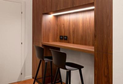 Sleek private phone booth with a white stool and blue flooring.