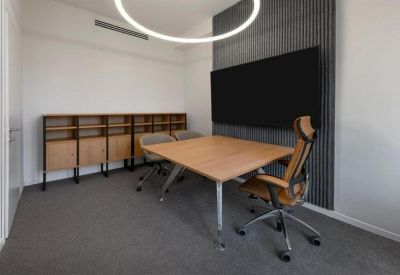 Built-in wood cabinetry workspace with black stools and terracotta-coloured carpet.