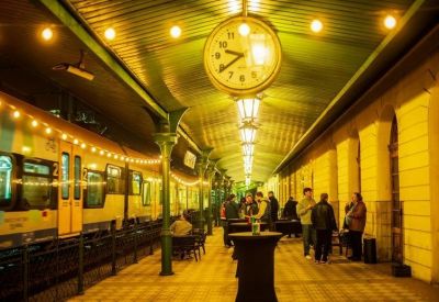 Outdoor train platform event space with a vintage clock and string lights.