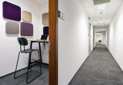 Individual workstation booth with a high chair and colorful acoustic wall panels.