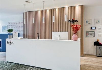 Minimalist white reception desk set against a warm wood-paneled feature wall.