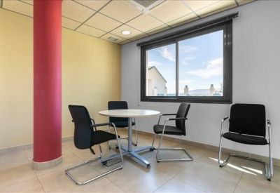 Meeting room with a round table and a bold red architectural column.