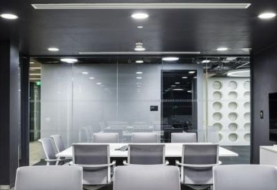 Professional conference room with a long white table and modern grey seating.