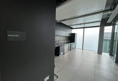 Clean, modern pantry area with dark cabinetry and a large window providing natural light.