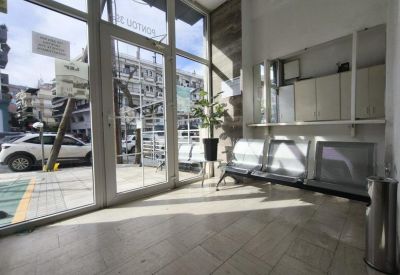 Waiting area with silver benches located near a large glass entrance door.