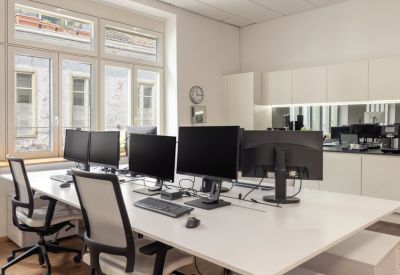 Communal office area with kitchen facilities and multiple workstations.