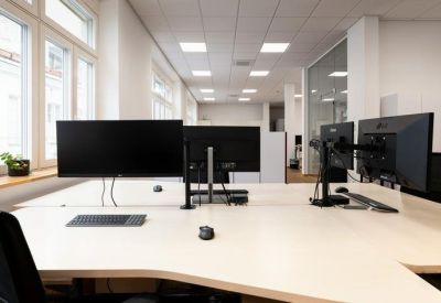 Open-plan workspace with multiple computer monitors on desks.