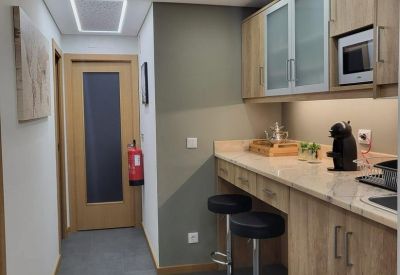 Kitchenette and breakout area with wooden cabinets, a breakfast bar, and high stools.