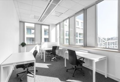 Bright corner office suite with multiple workstations and large windows.