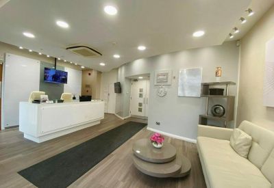Modern reception lobby with white desk, grey runner rug, and comfortable seating area.
