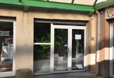 Main entrance of the Puget sur Argens Immeuble Center with white-framed glass doors.
