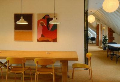 Long wooden dining table with yellow chairs and modern art at Pury Hill Business Park, Pury Hill Farm.