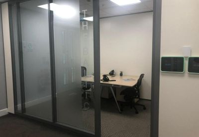 Compact internal office space viewed through a glass partition.
