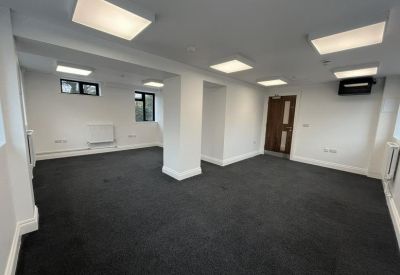 Versatile office space with recessed lighting and multiple windows.