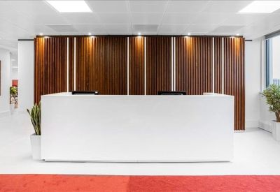 Bright reception desk with a vertical wood-slat feature wall and white minimalist counter.