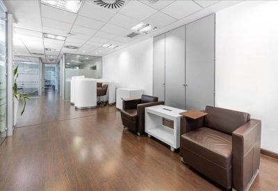 Bright meeting room with a square table and views through glass partitions.