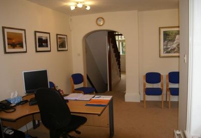 Reception area with an archway leading to a staircase and guest seating.