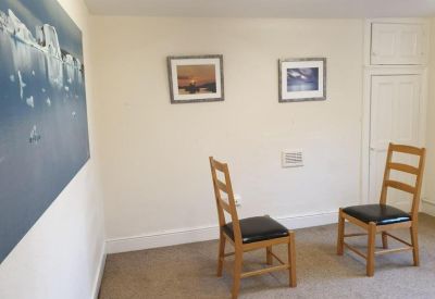Meeting room with two wooden chairs and artwork on the walls.
