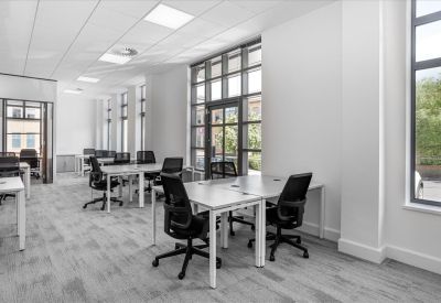 Spacious open-plan workspace at Rourke House, Watermans Business Park featuring white desks and large windows.