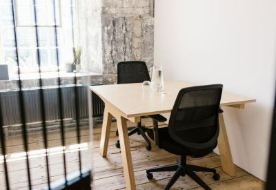 Private office with two chairs and a wooden desk.