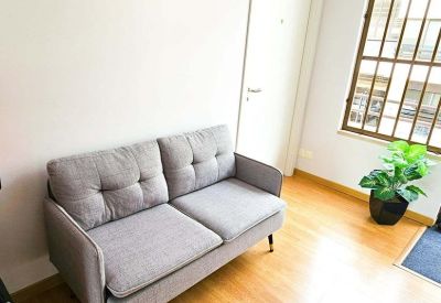 Lounge area with a grey fabric sofa and colorful city skyline artwork.