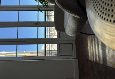 View from a seating area looking out through large glass balcony doors onto the city.