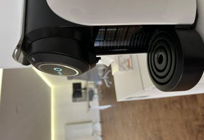 Kitchenette area featuring a modern white and black coffee machine and wooden floors.