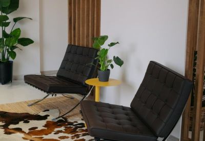 Lounge area detail with black tufted chairs and a small yellow side table.