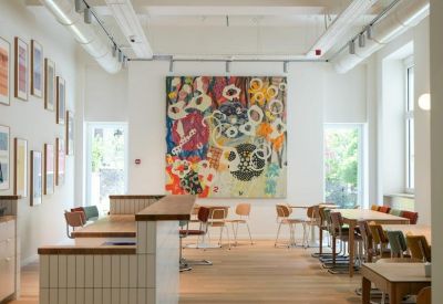Spacious cafe and breakout area with a large colorful mural and tiled service counter.