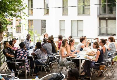 Group of people enjoying an outdoor lunch on a sunny terrace.