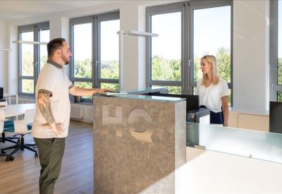 Professional reception desk with a branded stone counter and grey backsplash.