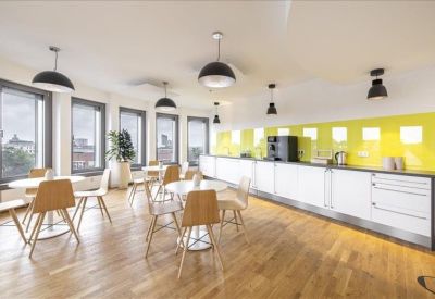 Modern cafeteria area with a long white counter and a bright yellow feature wall.