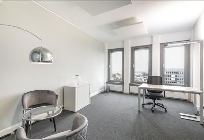 Private office featuring a desk, ergonomic chair, and a chrome floor lamp.