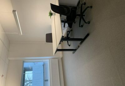 Private office space with a white sit-stand desk and a view through the window.