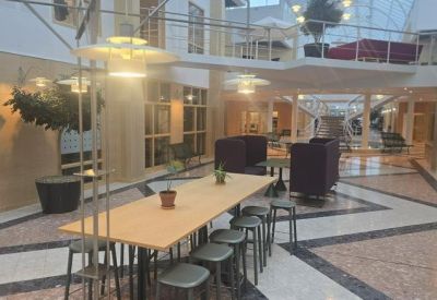 Spacious indoor courtyard with a long wooden communal table and modern pendant lighting.