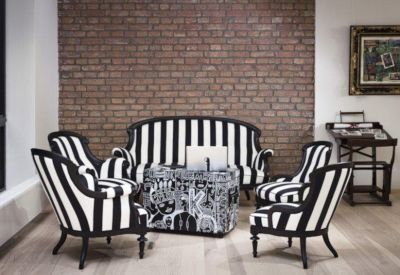 Stylish lounge area with black and white striped chairs against a brick feature wall.