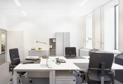 Spacious bright office suite featuring a large four-desk workstation setup.