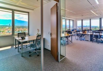 Bright corner office with large windows and a view of the mountains.