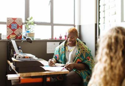 Bright private office featuring a wooden desk near a large window with natural light.
