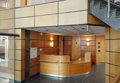 Reception area with a curved wooden desk and stylish panelled walls.